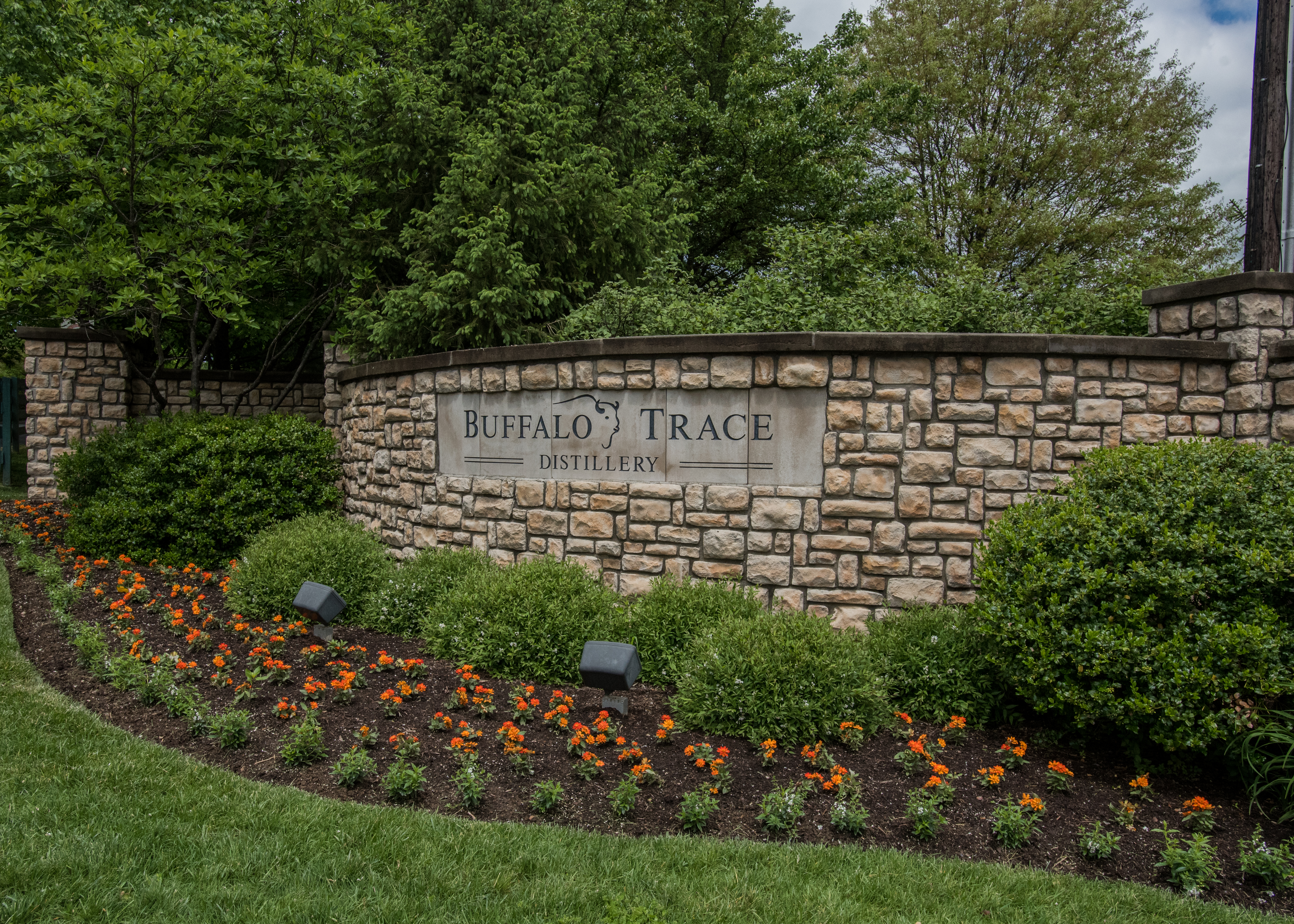 Stone entrance sign for Buffalo Trace Distillery surrounded by landscaping.