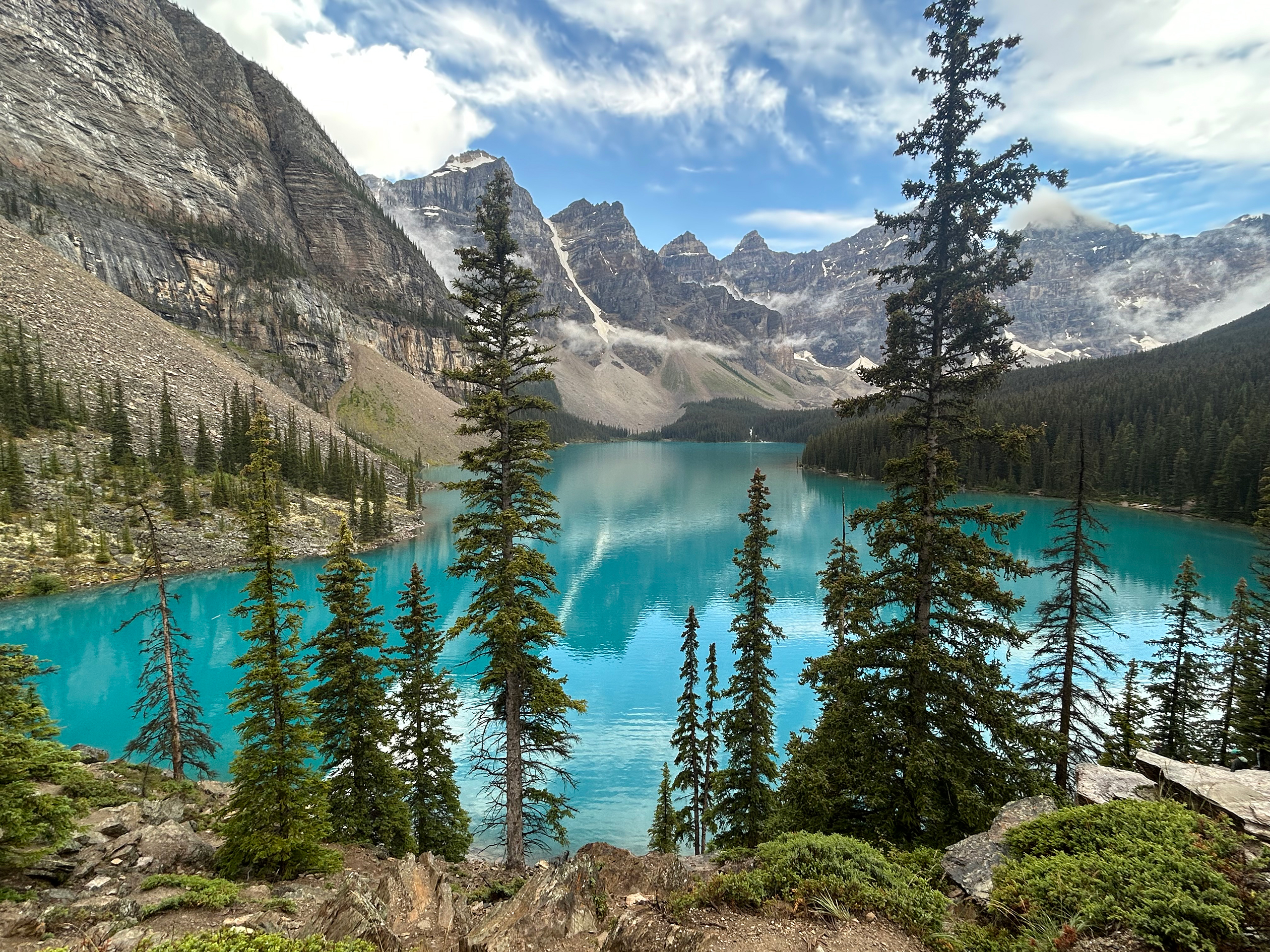 Turquoise waters of Lake Louise surrounded by rugged peaks and dense alpine forest.