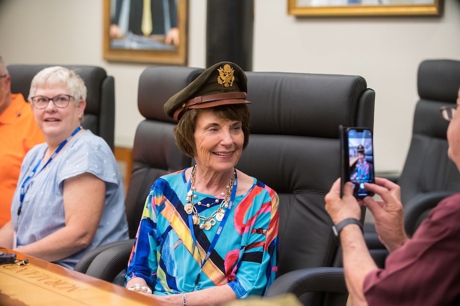 A lady wearing a military hat and getting her picture taken
