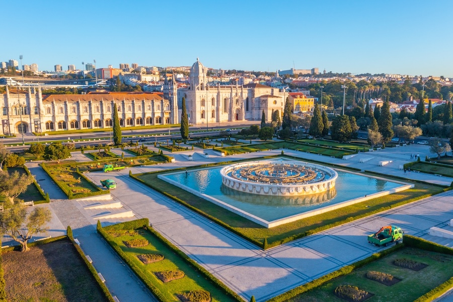 Aerial view of Jerónimos Monastery in Lisbon, Portugal, featuring gardens, a grand fountain, and historic architecture.