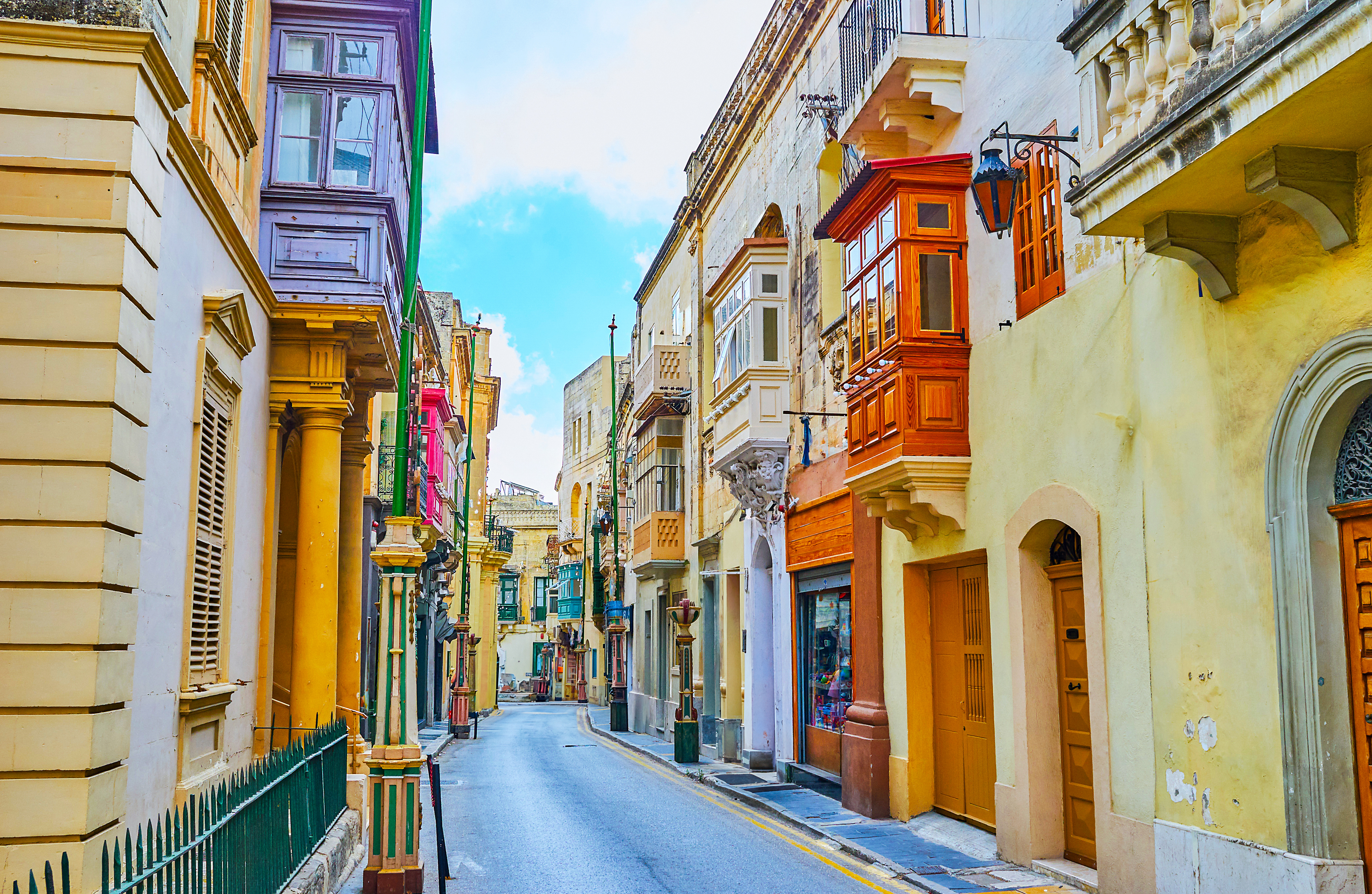 Narrow street with historic balconies in Rabat, Malta.