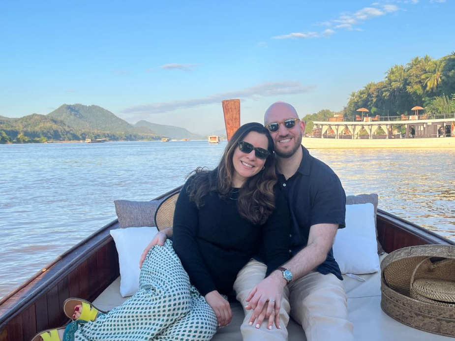 Mary and Niko smiling in a boat on the river