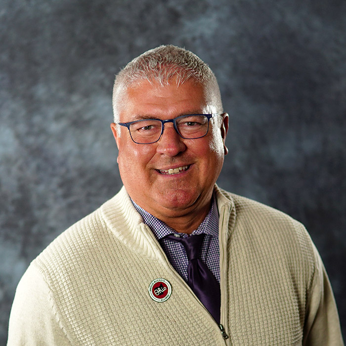 Craig Little portrait wearing tan zip up cardigan