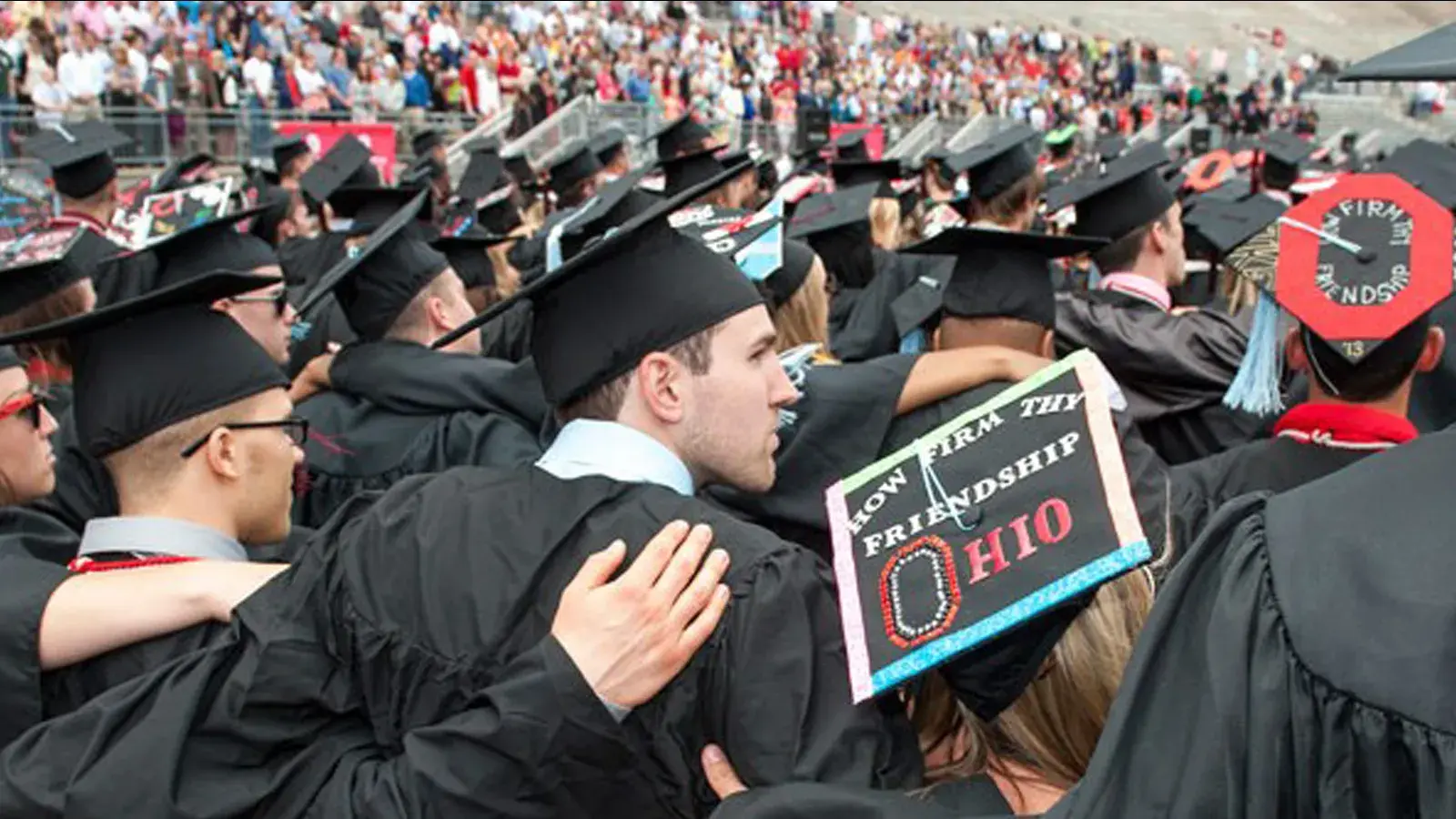 Students swaying arm in arm during graduation in the Shoe