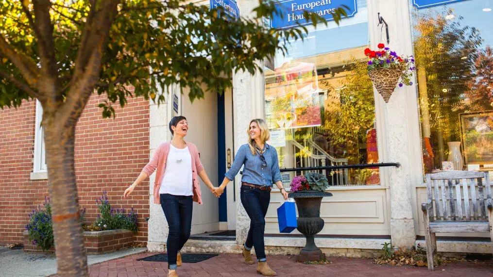 Two women walk through German Village holding hands