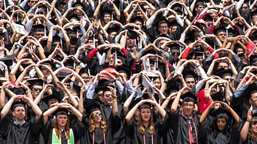 crowd of new graduates making an O with their hands