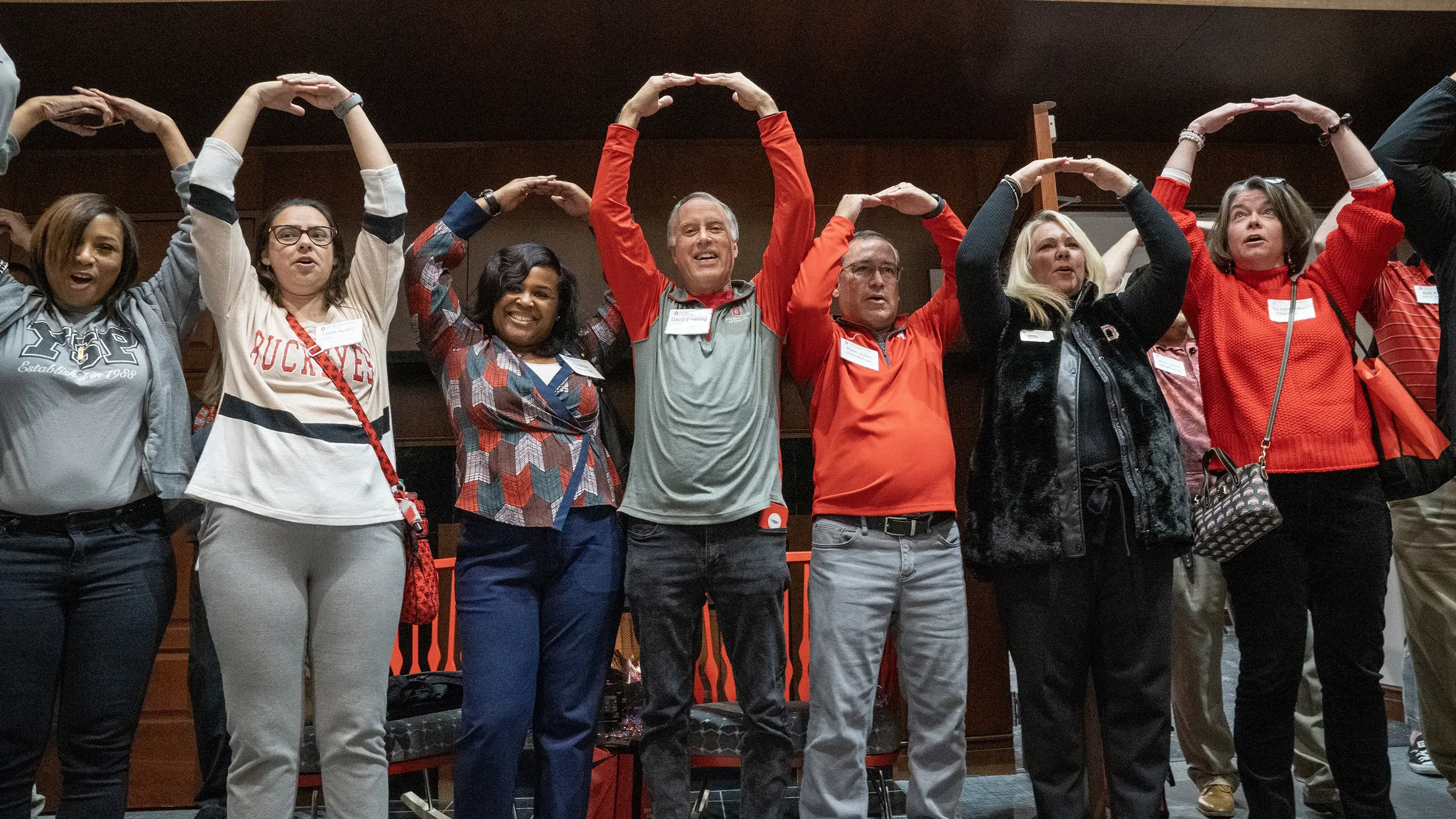Alumni club/society leaders at the Club Society Symposium making an 'O' with their arms