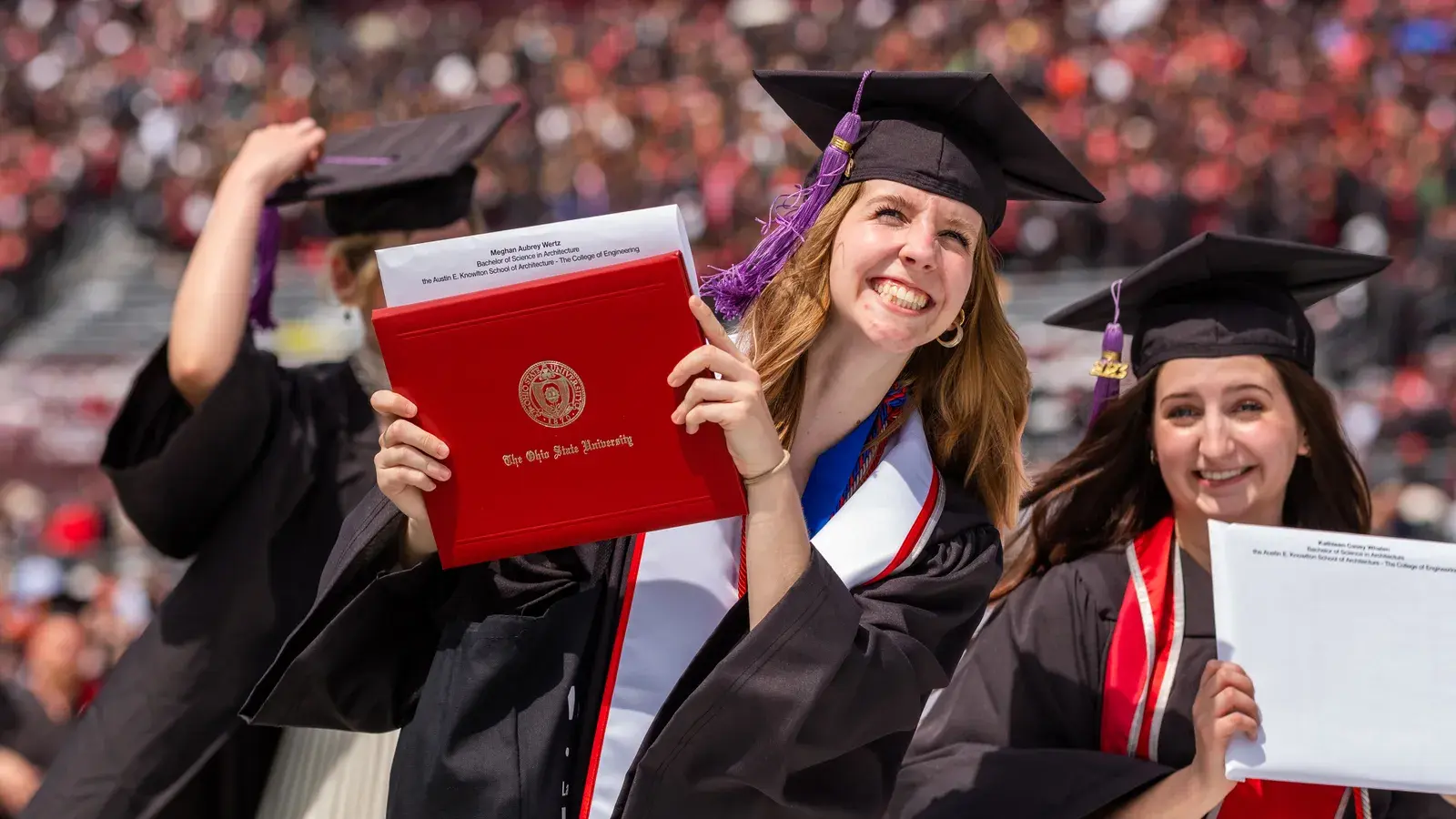 woman holds a college diploma