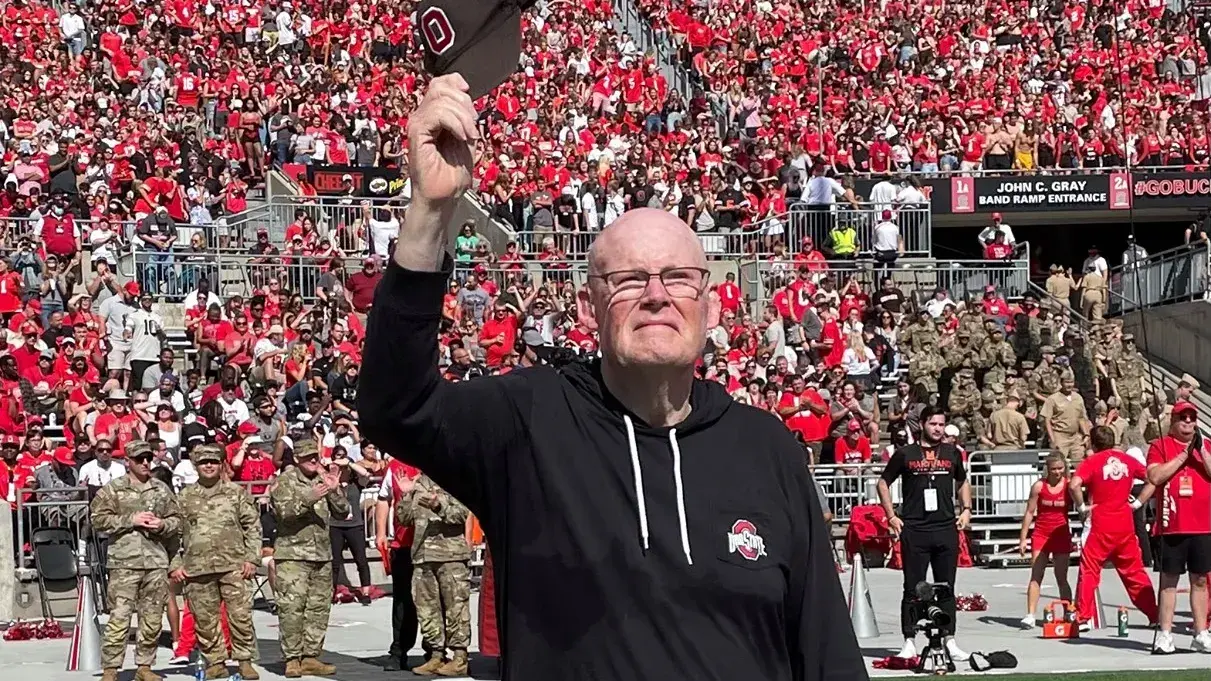 man standing in ohio stadium saluting the crowd