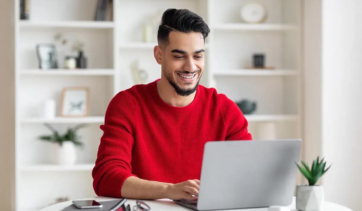 smiling man using a laptop