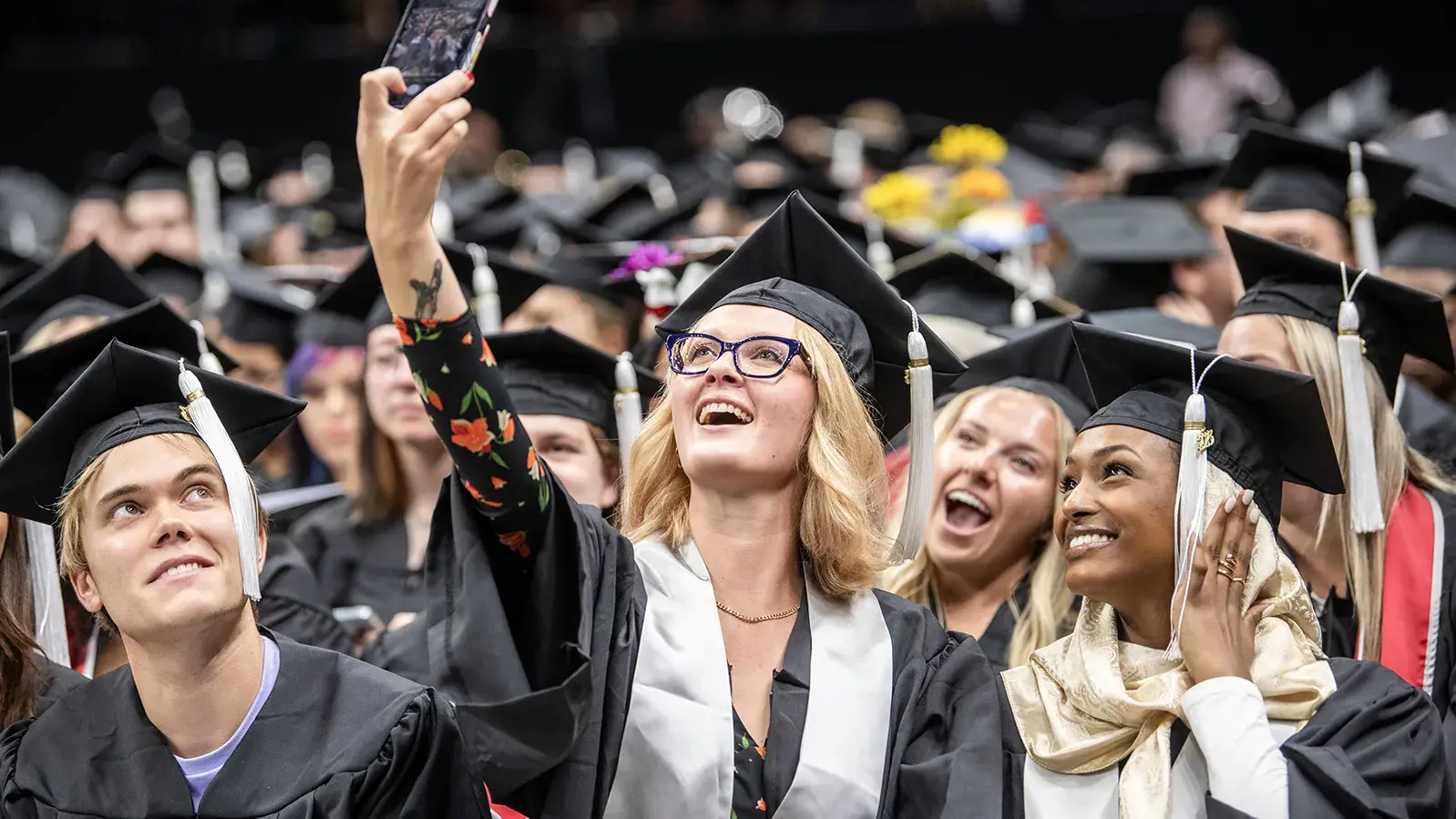 college graduate taking a selfie with their phone