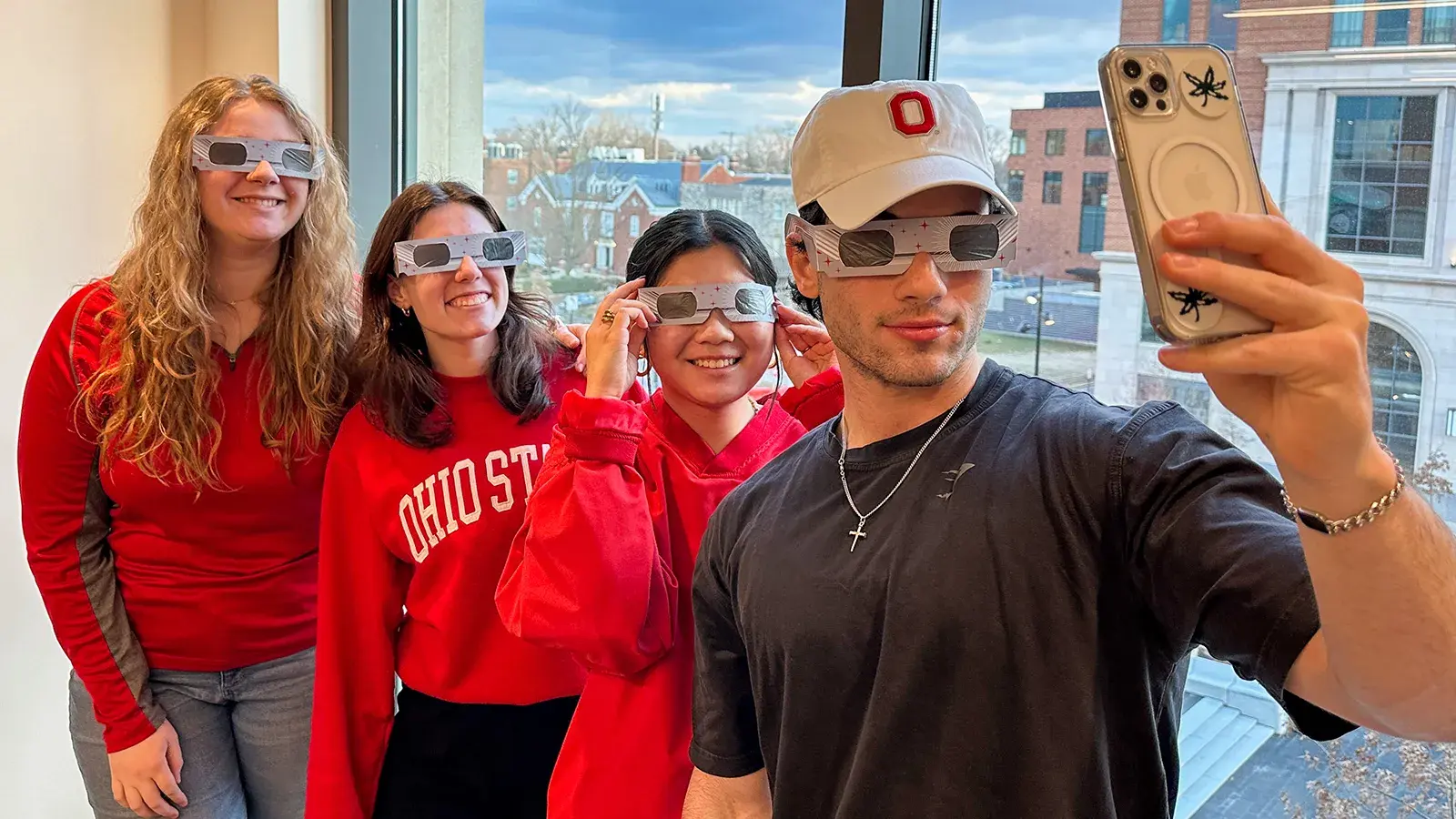 four students wearing eclipse glasses