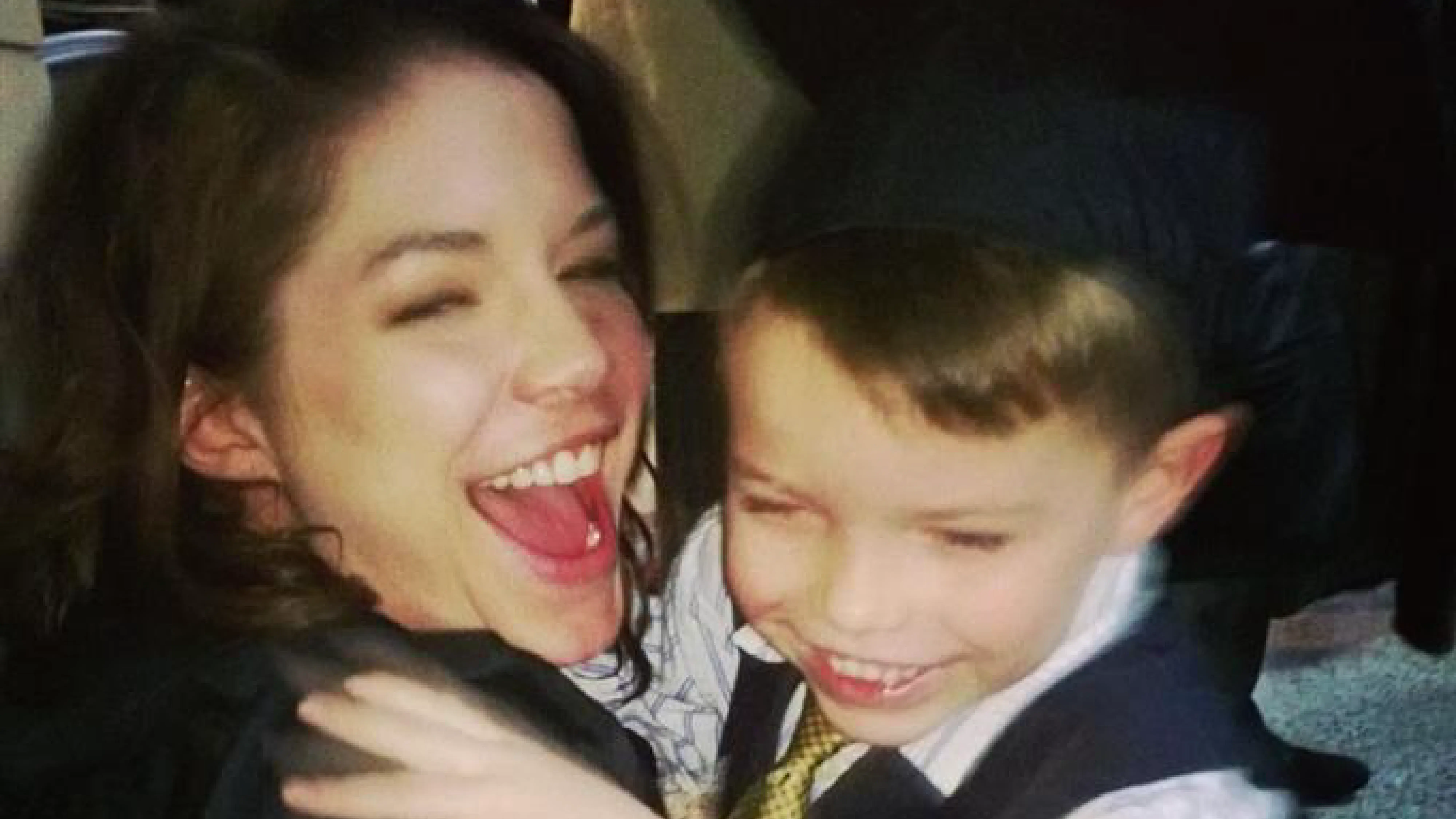 Woman and a boy hugging and laughing