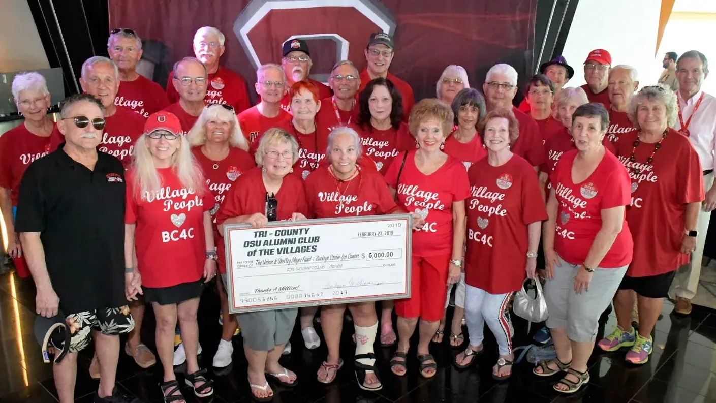 OSU Alumni wearing red shirts holding a Tri County Club sign