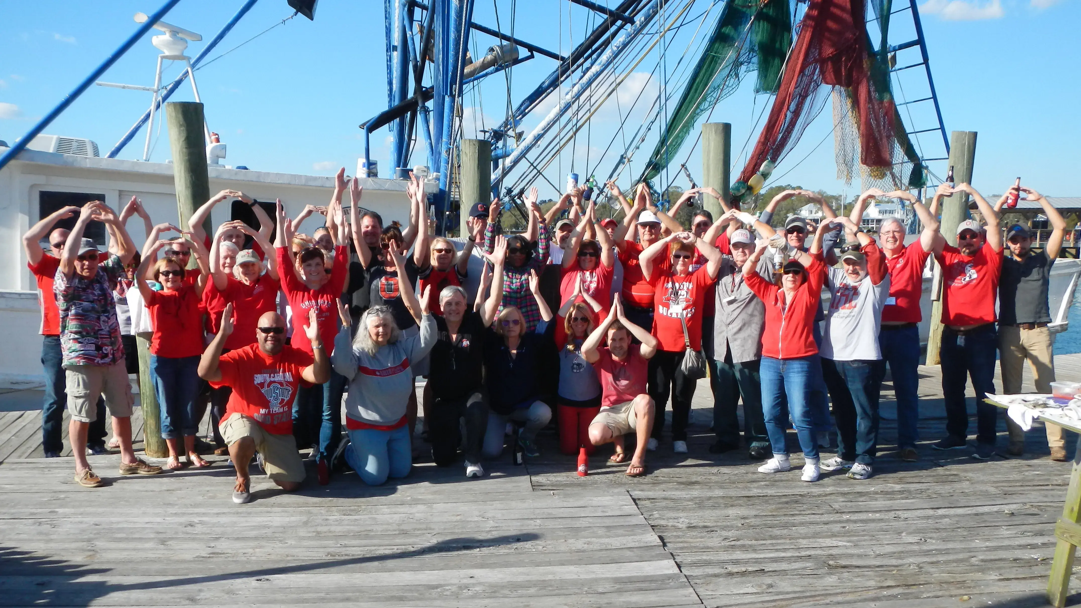 Ohio State alumni posing for a picture on the docs during an oyster roast