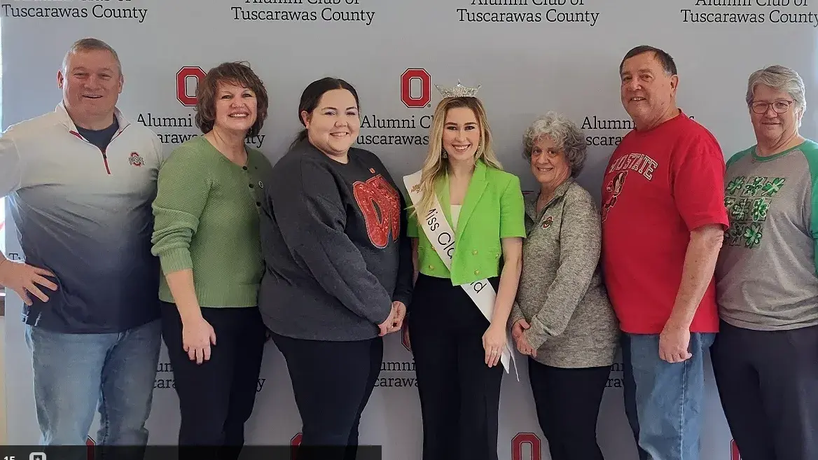 ohio state alumni posing with a pageant queen in front of an ohio state backdrop