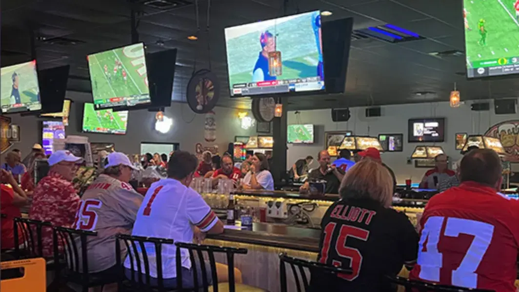 ohio state alumni watching a buckeye's football game at a bar