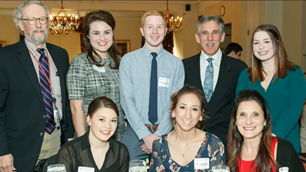 small group of ohio state alumni in business casual wear posing for a photo at an event