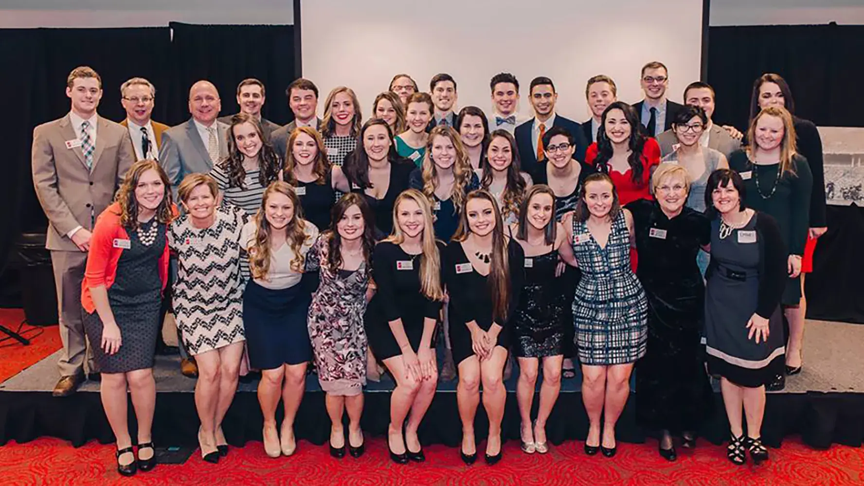 ohio state alumni in semi-formal suits and dresses posing for a group picture