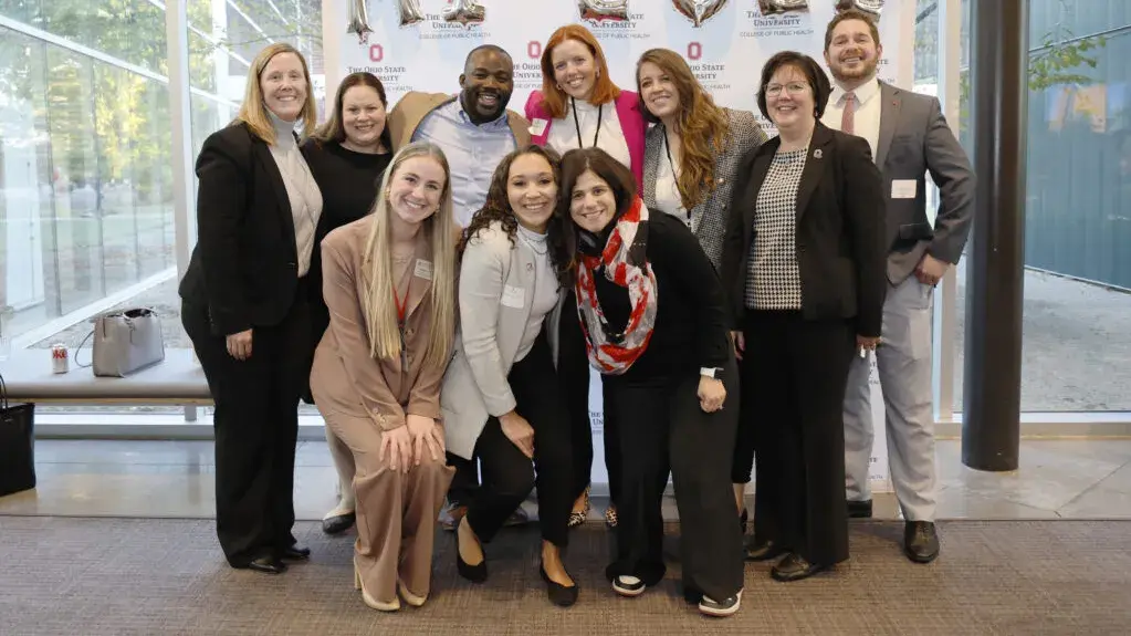ohio state alumni posing for a photo in front of a 2022 ohio state banner