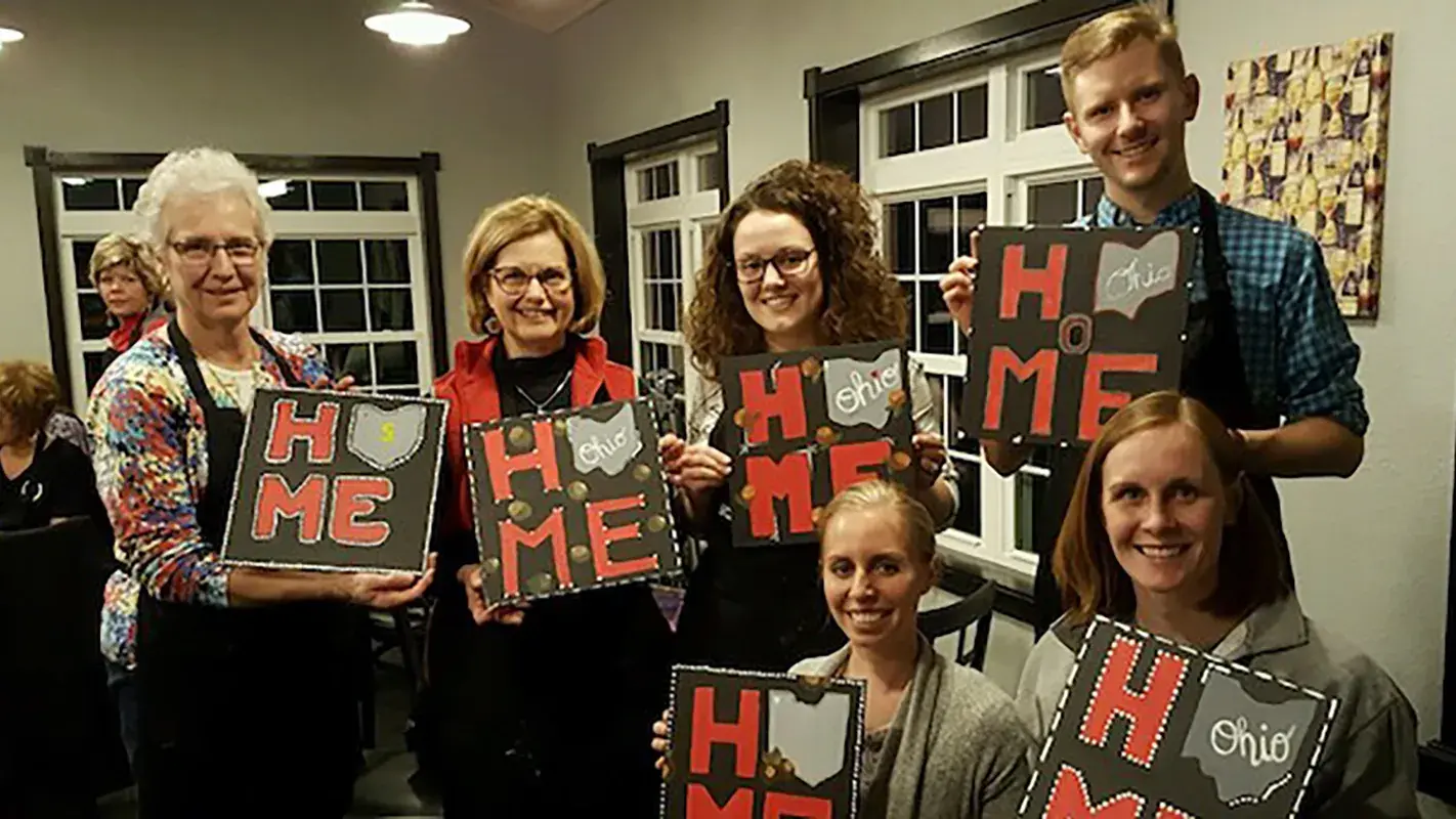 group of five individuals of different ages holding an Ohio is home craft