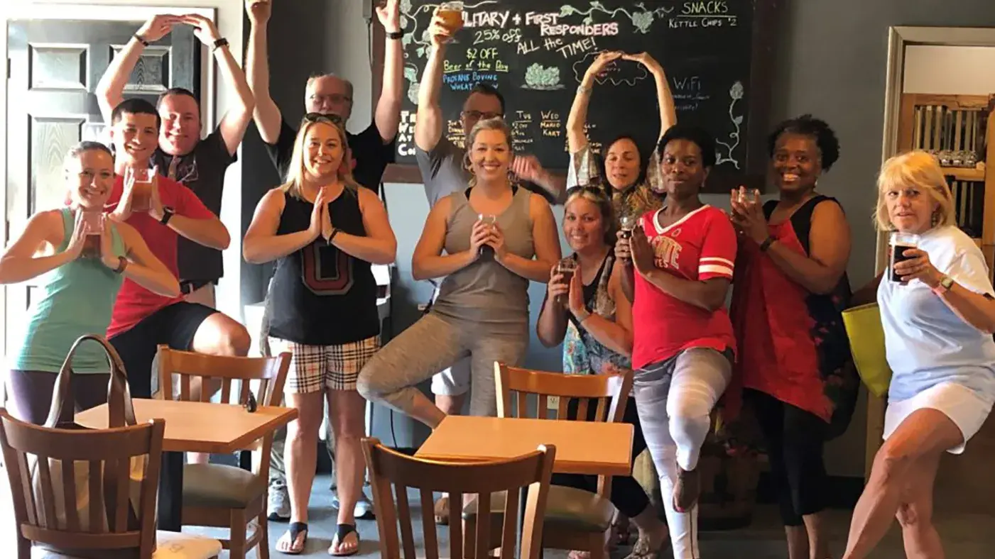 group of ohio state alumni posing for a photo while doing yoga poses and the O H I O