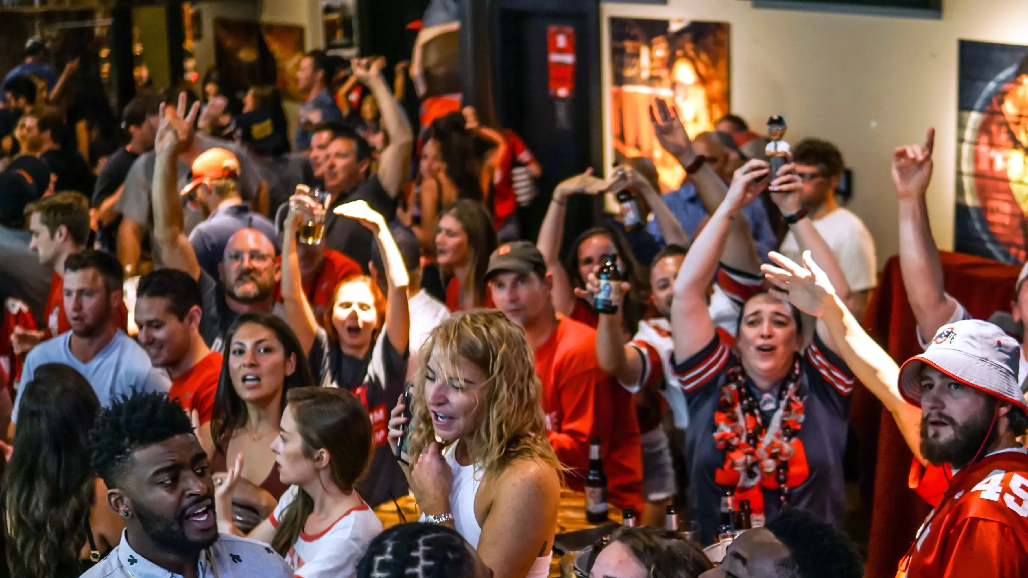 large group of ohio state alumni celebrating at a bar