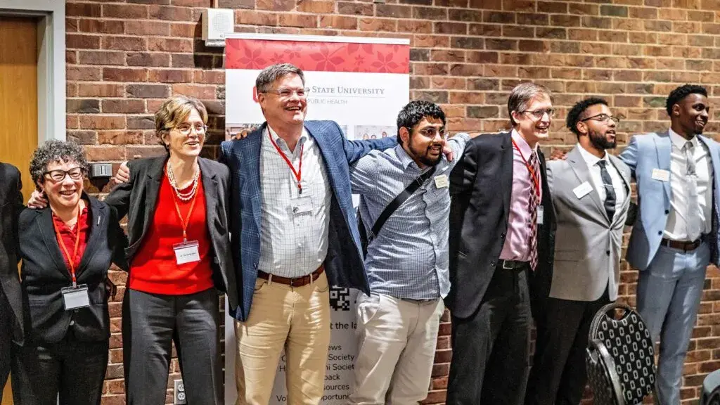 group of six people locking arms with each other while standing side to side