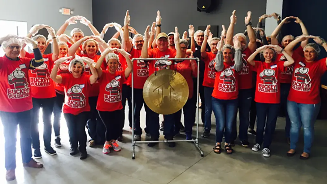 ohio state alumni wearing red ohio state shirts pose for a photo while at a volunteering event