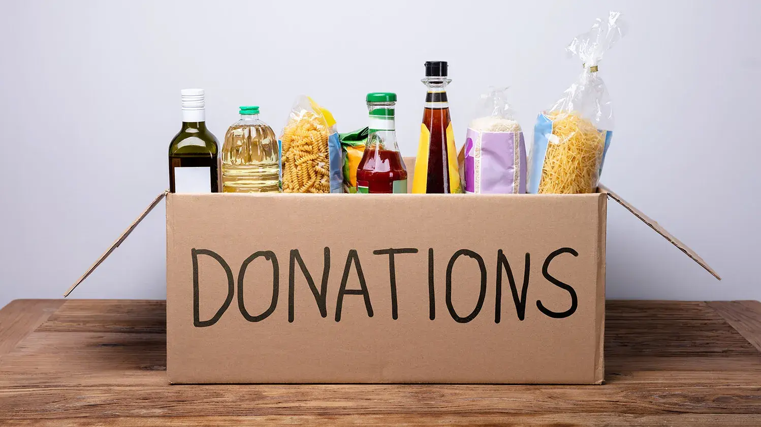 collection of non-perishable food items in a cardboard box