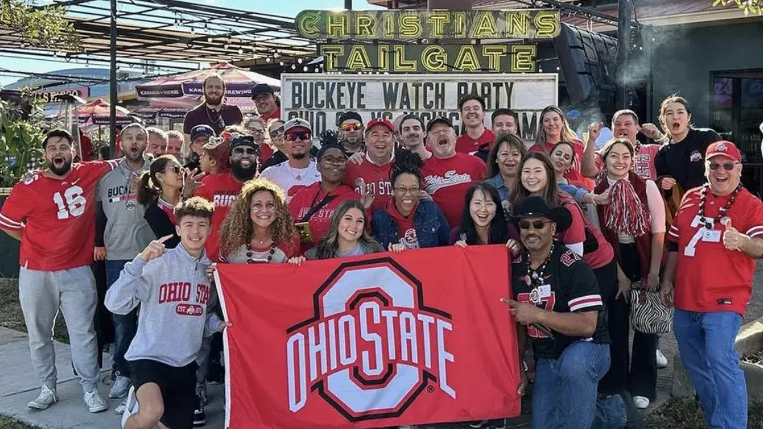group of people holding a scarlet ohio state flag