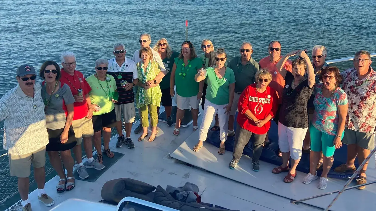 group of people wearing buckeye shirts while standing on a boat