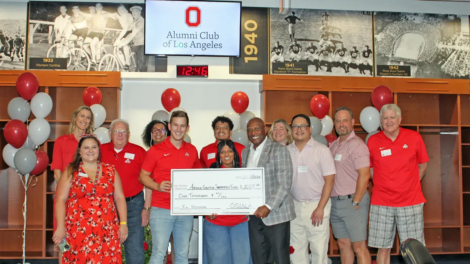 dozen of people posing with an oversized check