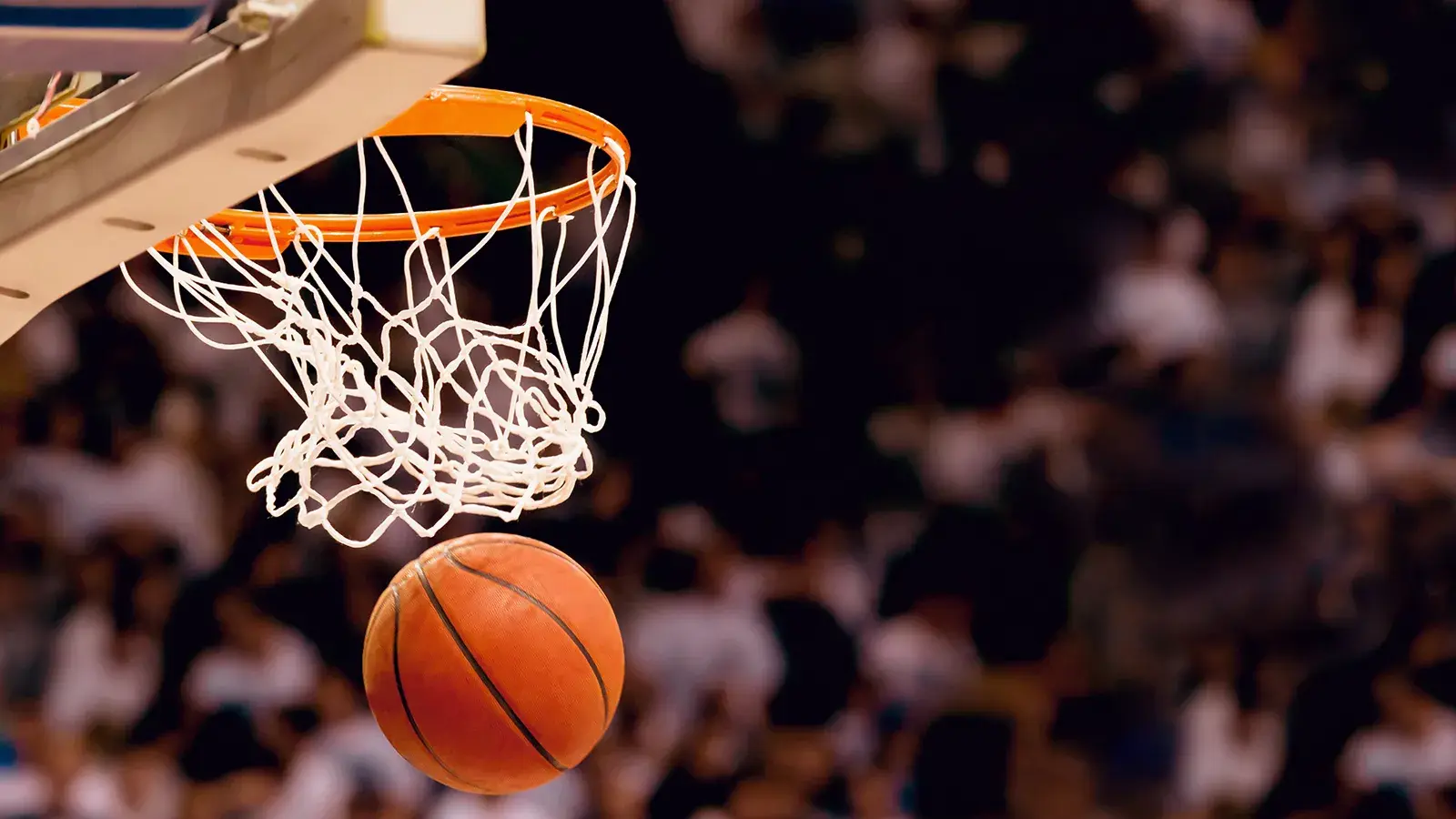 orange basketball going through a basketball hoop