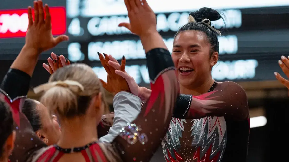 ohio state women's gymnast smiling and giving teammates high fives