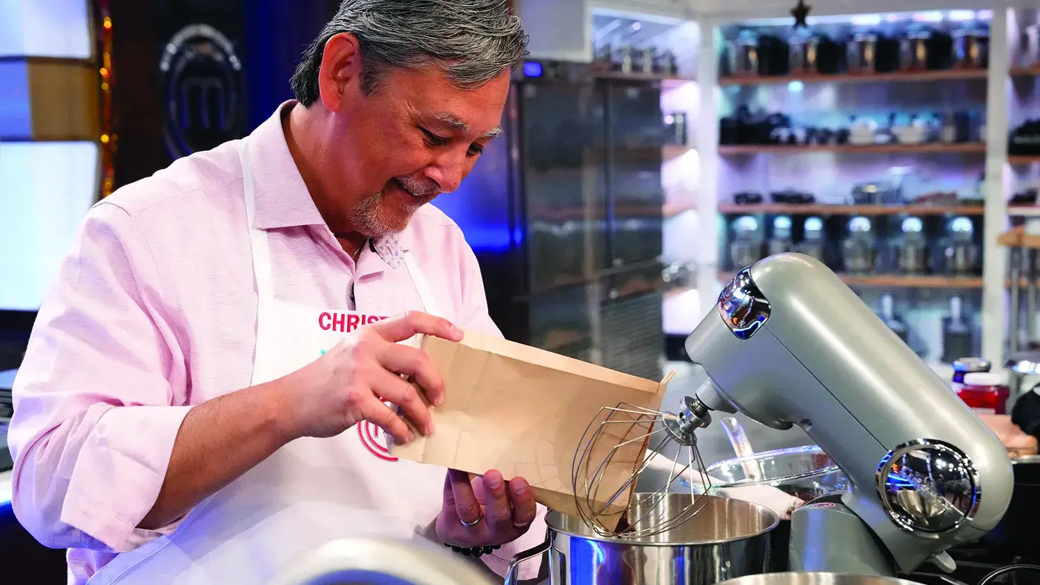Chef Chris Walinski pours flour into a mixing bowel while making his much praised cake on the television show.
