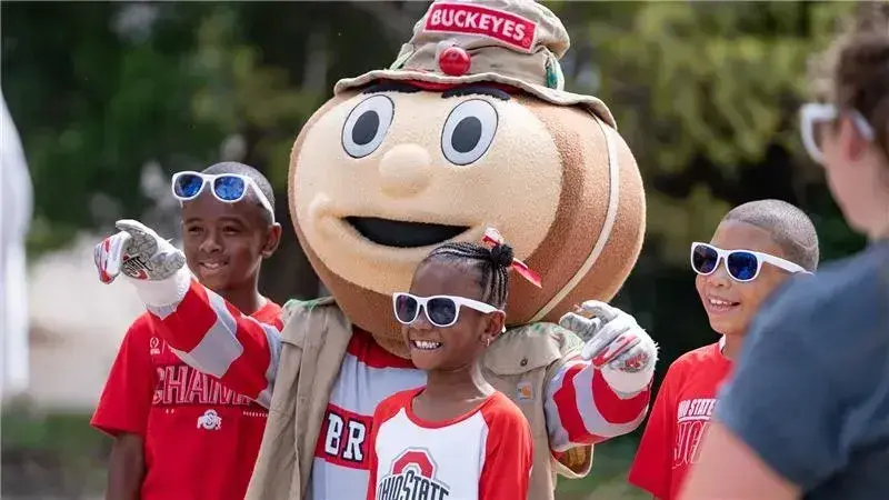 kids hanging with Brutus Buckeye at an event