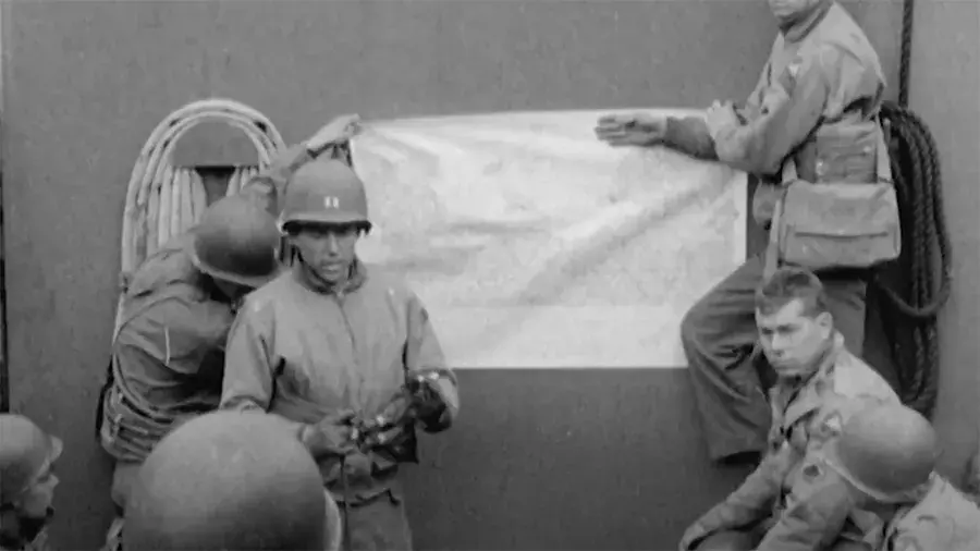 WWII soldiers having a meeting and looking at a map on a wall