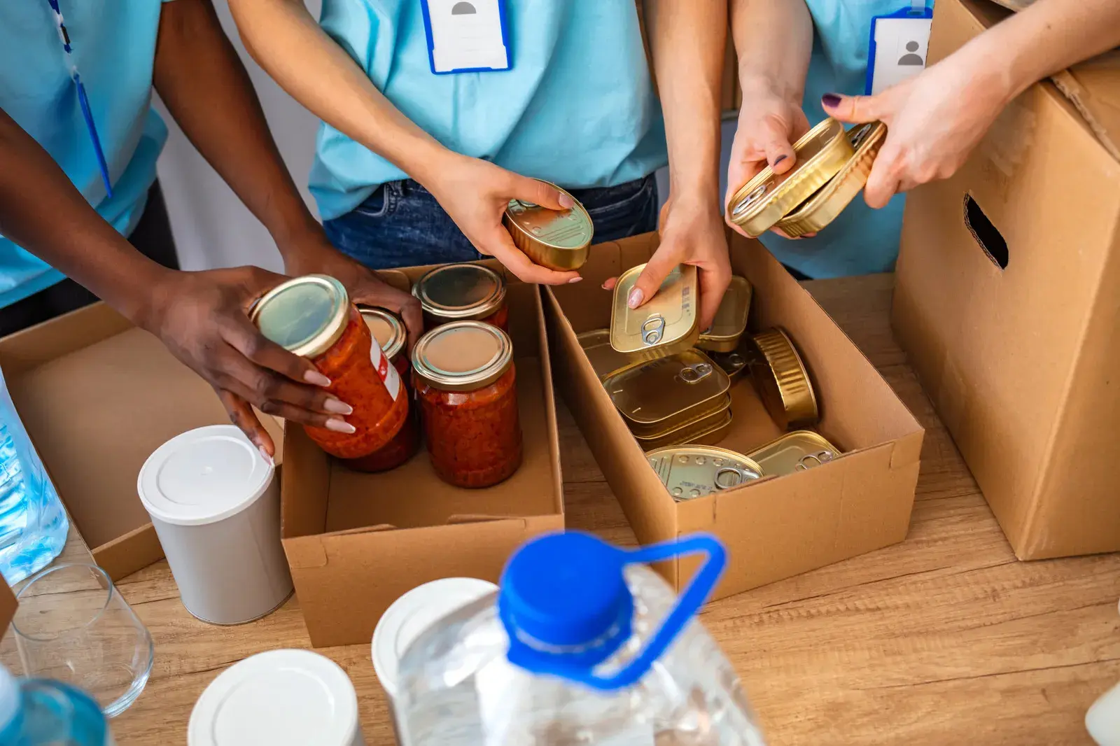 People volunteering and packing container with food 