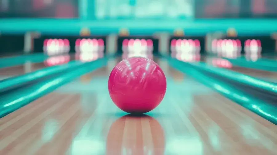Pink bowling ball on a neon-lit alley