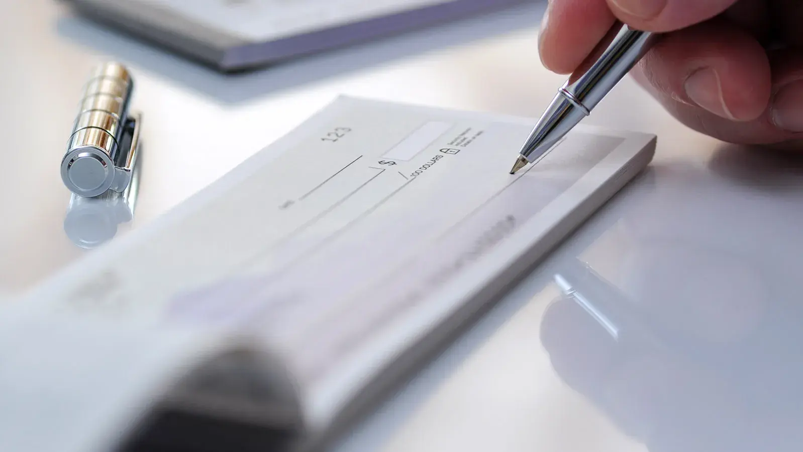 Close-up businessman hand hold pen fill a banque cheque document