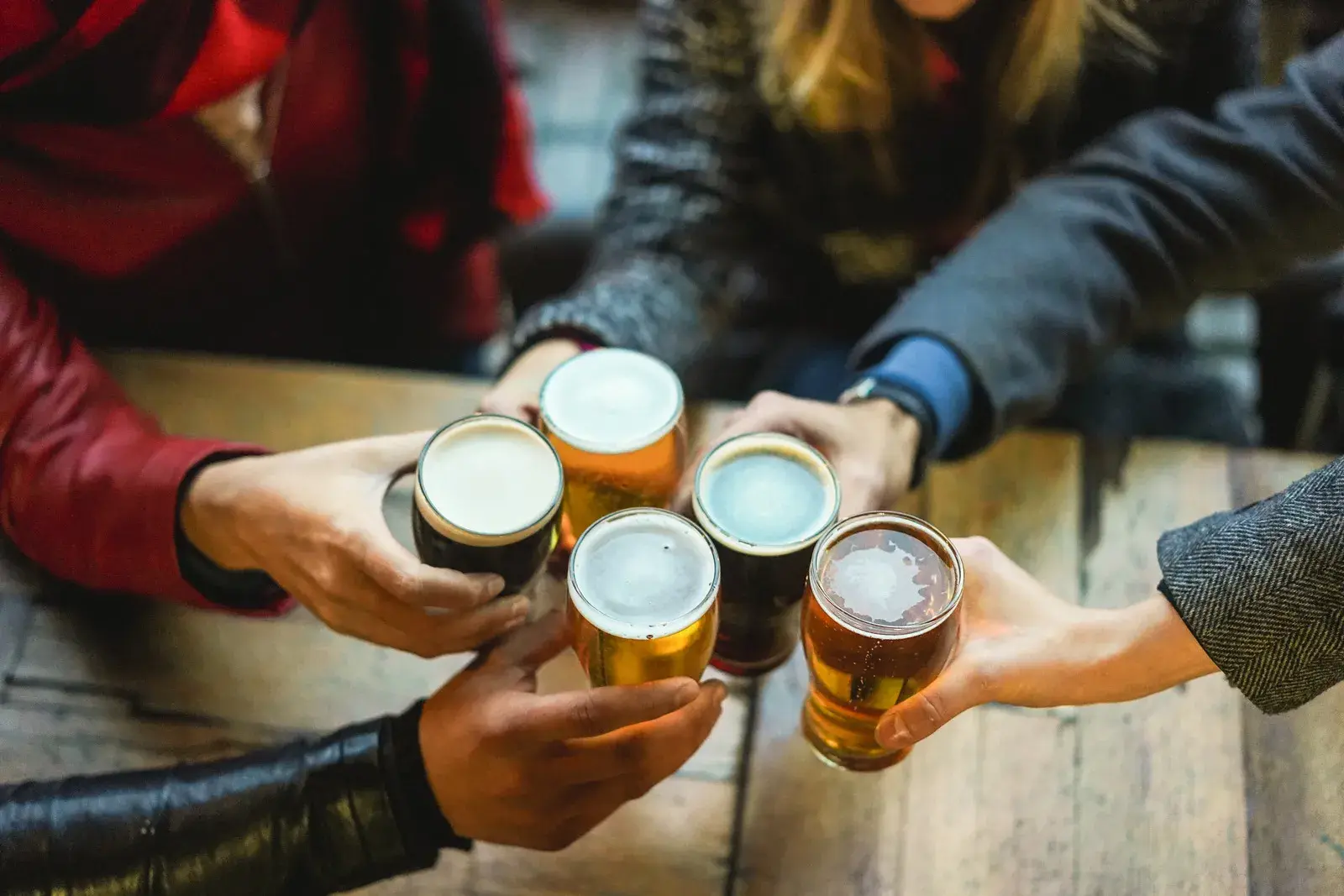 group of people holding beer at pub