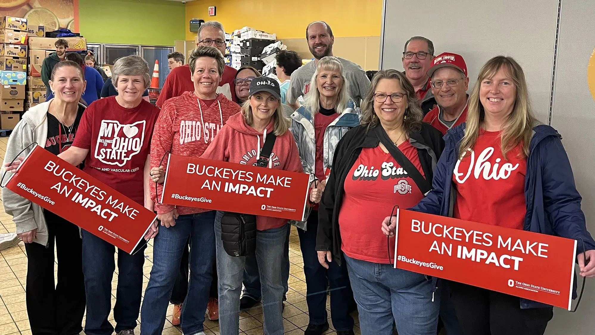 dozens of volunteers wearing Buckeye T-shirts and scarlet impact banners