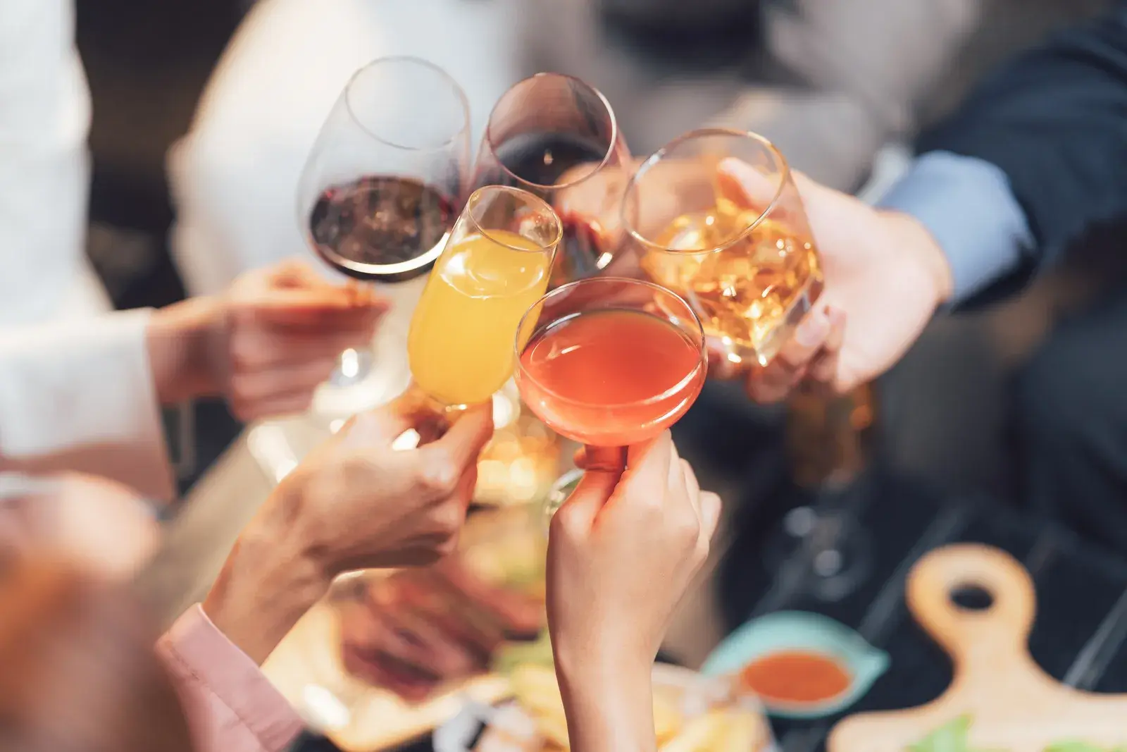 friends clicking their wine glasses together 