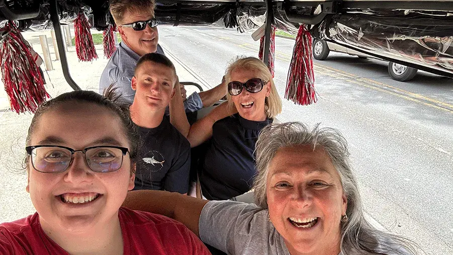 Molly Ranz Calhoun driving with people in a golf cart on Move-In Day