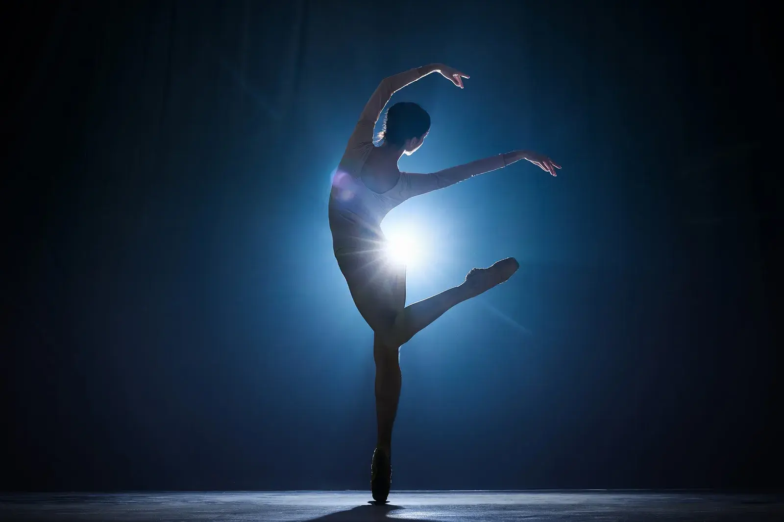 ballet dancer on stage, with blue background