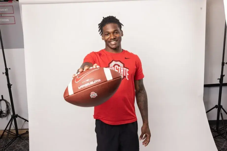 photo of Jeremiah Smith holding out a football