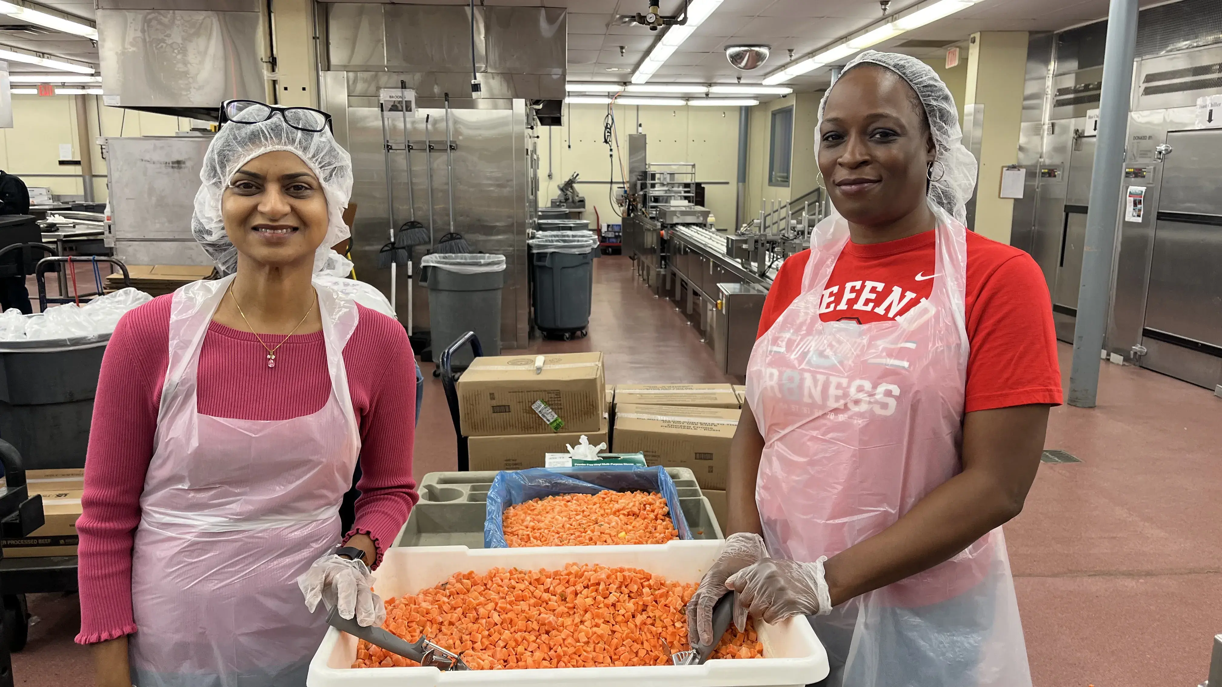 two buckeye volunteers working in a kitchen to pack meals