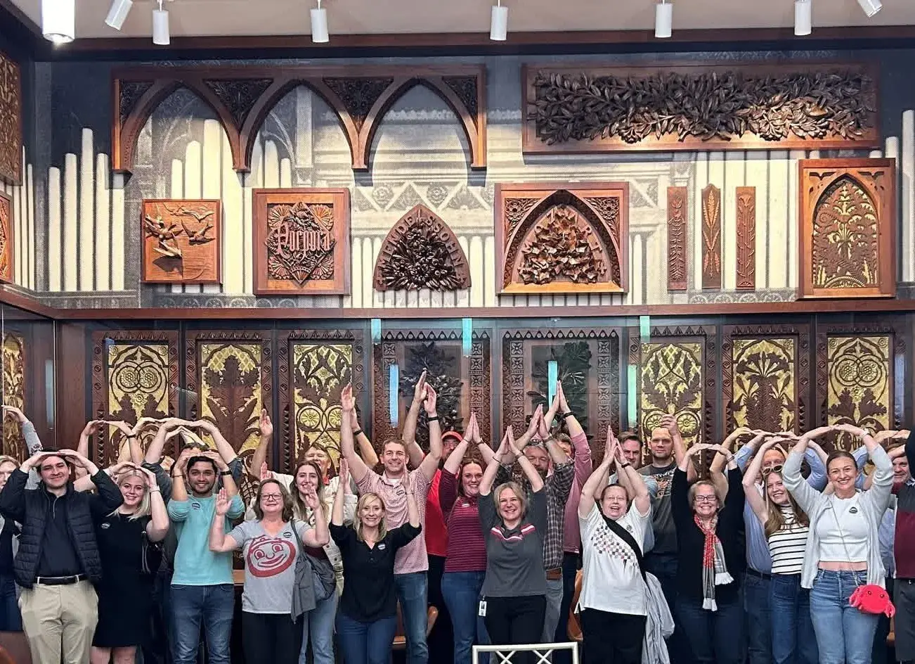 members of the cincinnati alumni club holding their arms up doing OHIO