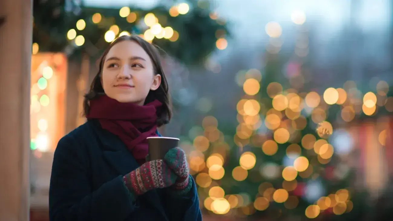 woman wearing winter clothes holding a hot beverage